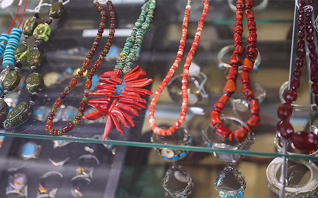 Assorted handcrafted turquoise, coral, and gemstone beaded necklaces on display